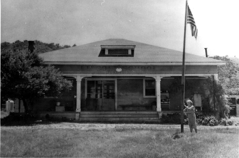 Teacher standing by the flag pole - Adelaida School house